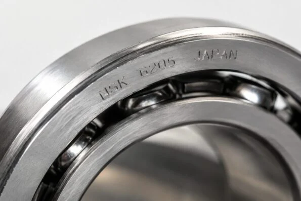 Macro close-up of engraved markings on the side face of an NSK precision bearing ring